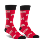 Pair of red crew socks with black cuffs.  Features a pattern of white video game controllers and consoles.