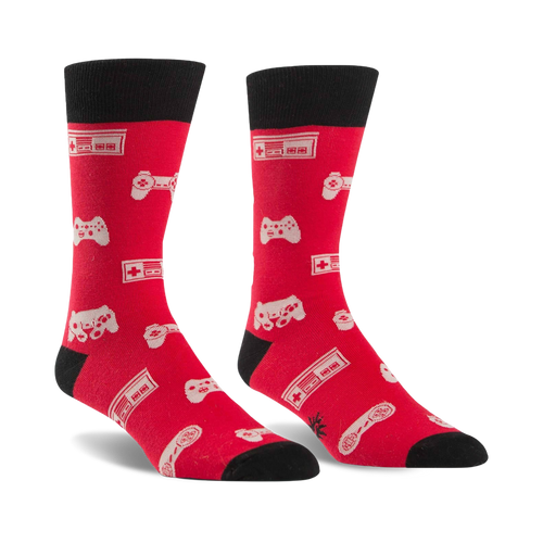 Pair of red crew socks with black cuffs.  Features a pattern of white video game controllers and consoles.