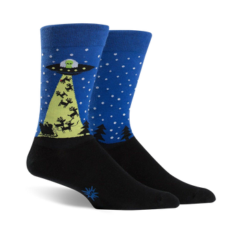 blue crew socks featuring a green alien spaceship abducting a christmas tree with red ufo beam, black pine trees, and white snowflakes.   