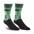 Pair of crew socks in green and black. The design features grey aliens, UFOs, and a starry night scene.