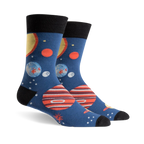 Pair of crew socks, navy blue with colorful planets, stars, and black cuffs. Fun space-themed design.