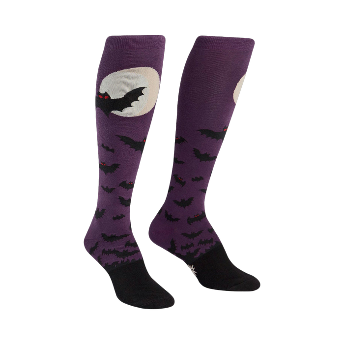 Pair of purple knee-high socks.  Design features black bats flying around a full moon.  Black cuffs and toes.