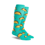 Pair of teal knee-high socks with a repeating pattern of cartoon dinosaurs shaped like tacos. 