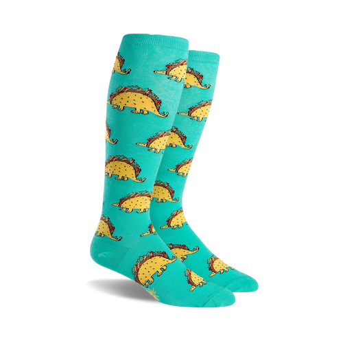 Pair of teal knee-high socks with a repeating pattern of cartoon dinosaurs shaped like tacos. 