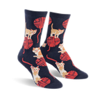 A pair of crew socks in navy blue with a playful pattern of orange kittens batting at red yarn balls.