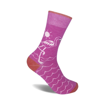pink flamingo standing on one leg in front of a yellow sun. palm trees and waves. crew length ladies' flamingo socks.  