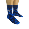 Pair of navy blue crew socks with bright blue flowers and 'DOMESTIC AF' text, shown on a model's feet.