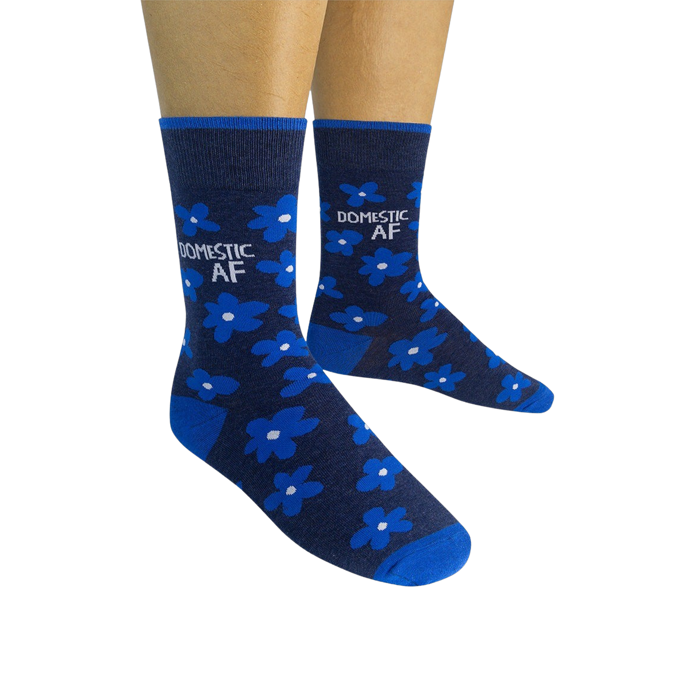 Pair of navy blue crew socks with bright blue flowers and 'DOMESTIC AF' text, shown on a model's feet.