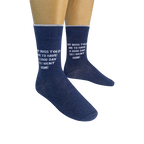 Lifestyle shot: Two pairs of navy blue socks with the witty message are modeled on feet.