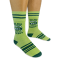 Person wearing light green socks with dark green stripes. The socks feature a pickle jar graphic with Big Dill Energy text.