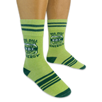 Person wearing light green socks with dark green stripes. The socks feature a pickle jar graphic with Big Dill Energy text.