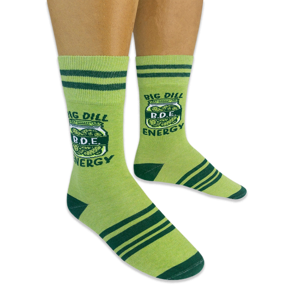 Person wearing light green socks with dark green stripes. The socks feature a pickle jar graphic with Big Dill Energy text.
