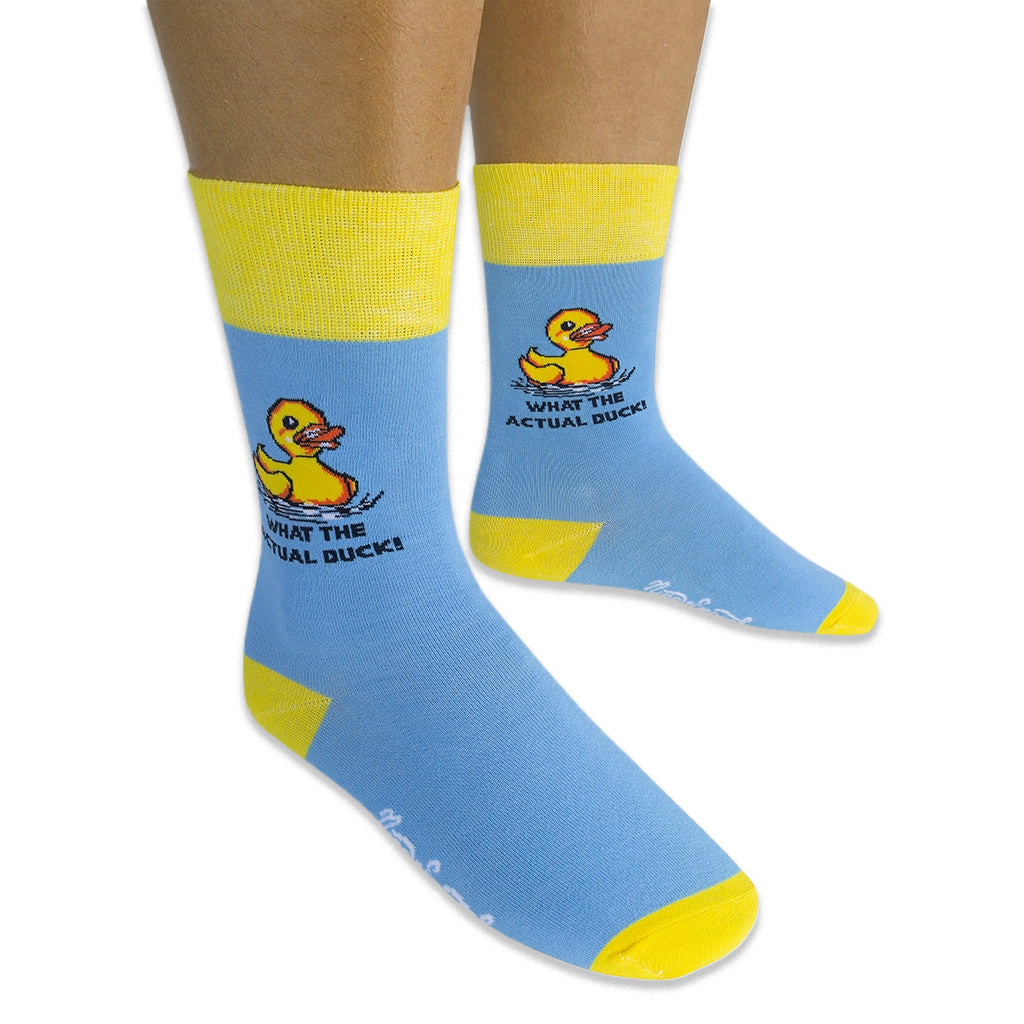 Person wearing light blue crew socks with yellow accents on a black background, showing the pixel rubber duck and text design.