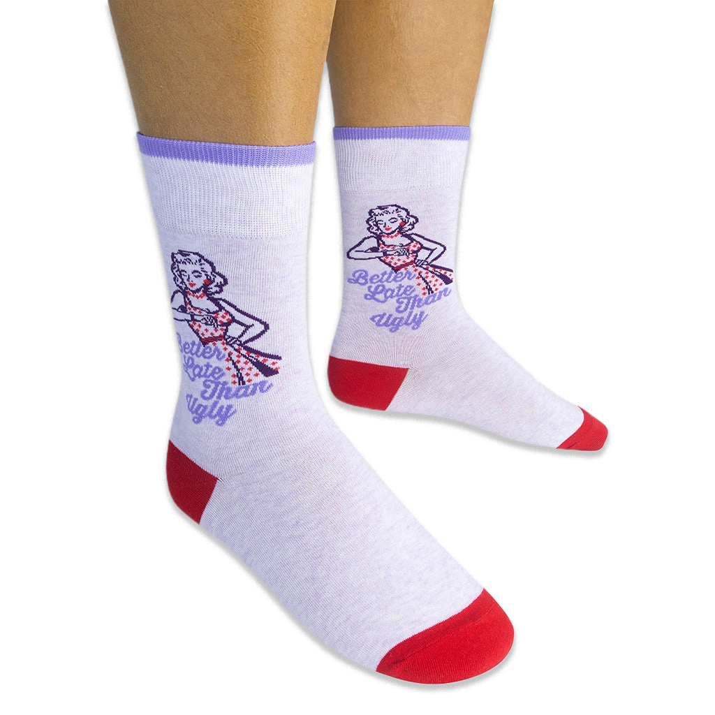 Person wearing light purple crew socks showing a retro woman checking her watch and Better Late Than Ugly text on the sides.