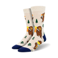 Cream-colored crew socks with a whimsical design of brown Bigfoot figures carrying backpacks, accented with green trees and a navy blue cuff.