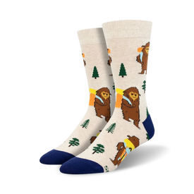 white crew socks featuring cartoon bigfoot hiking through green woods with brown trees. perfect for adventurers and bigfoot enthusiasts. men's size.