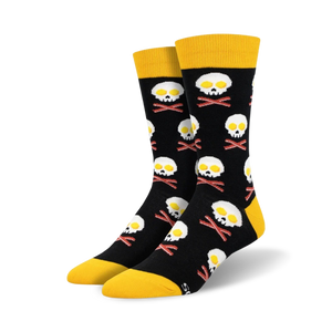 A pair of black crew socks with a fun design.  Yellow-topped socks feature skulls made of fried eggs and crossed bacon bones.