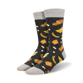 crew length men's socks feature a repeated pattern of bananas, bread slices, and fried eggs on a dark background.   