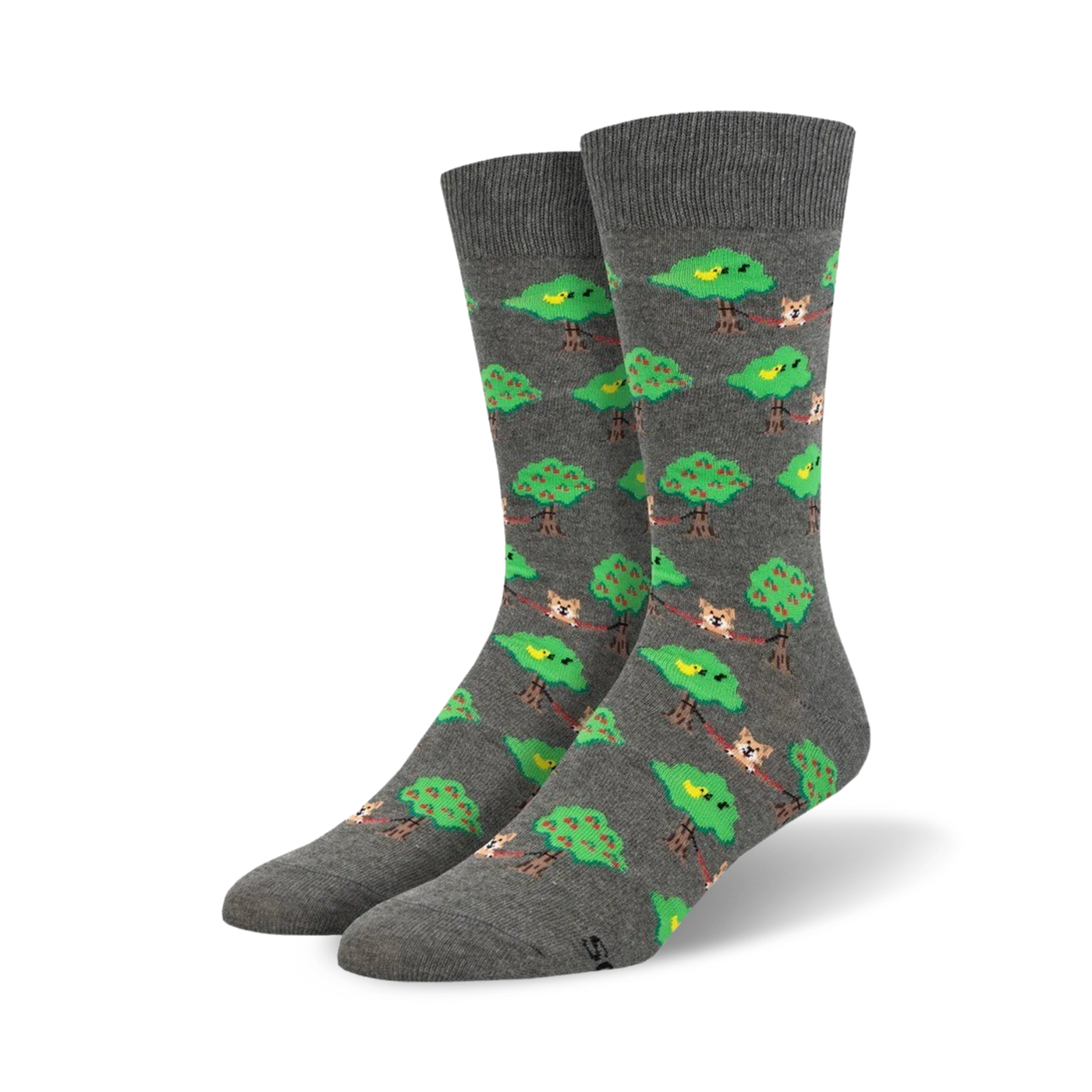Pair of grey crew socks with a repeating pattern of dogs lounging on branches between green apple trees, and small yellow birds.