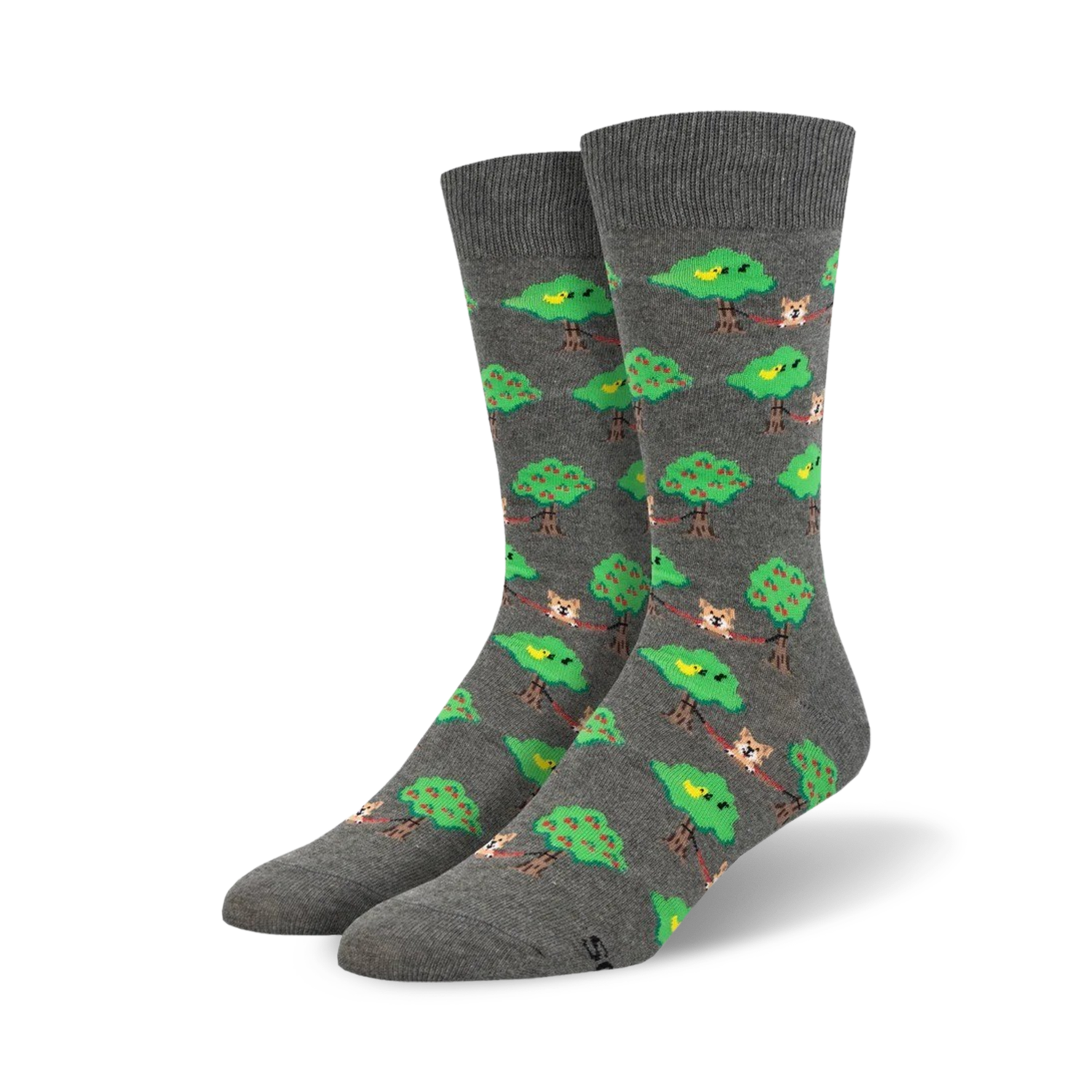 Pair of grey crew socks with a repeating pattern of dogs lounging on branches between green apple trees, and small yellow birds.
