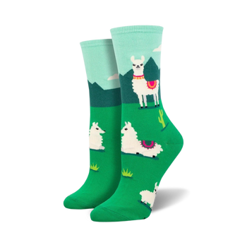white crew socks with pink and black detailed llamas standing in a green field with cacti and mountains in the background.   