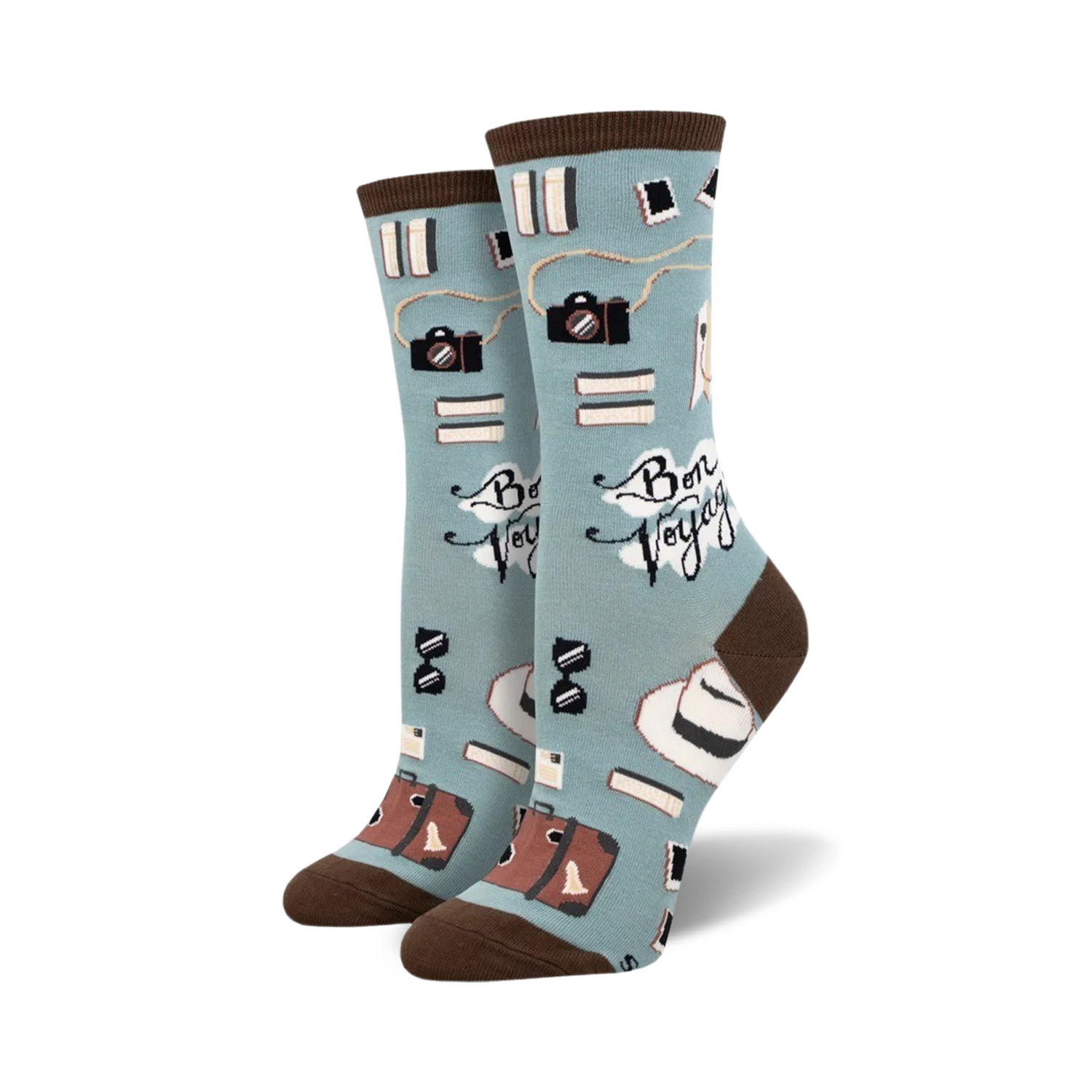 A pair of crew socks in teal and mint green, featuring cameras, books, hats, and suitcases; the phrase 'Bon Voyage' is printed on the socks.