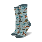 A pair of crew socks with a teal background. The socks feature a repeating pattern of hares, tortoises, and small flags.