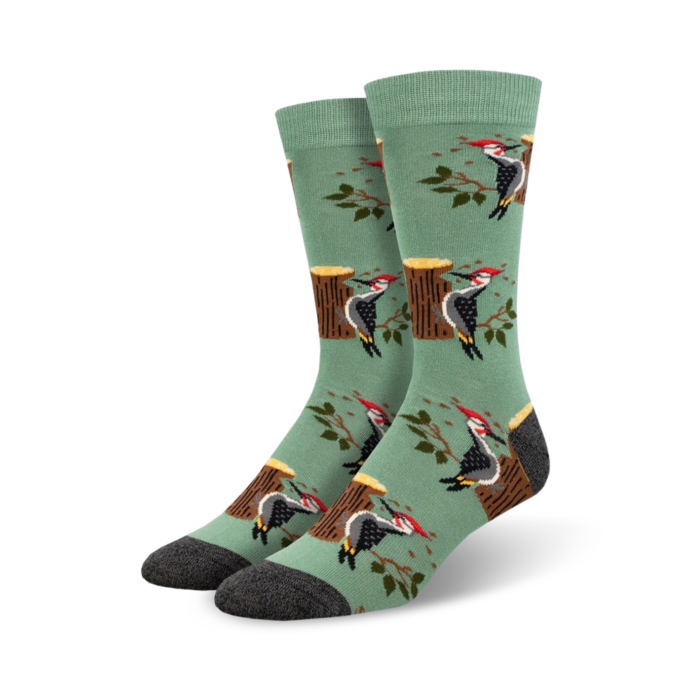 A pair of crew socks in sage green with a repeating pattern of woodpeckers on tree stumps and branches.