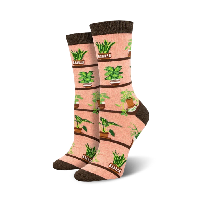 pink crew socks with green houseplants in brown pots, including snake plant, zz plant, and pothos designs.  