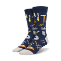 Pair of navy blue crew socks with a pattern of various tools, including hammers, saws, and measuring tools, in yellow and brown.