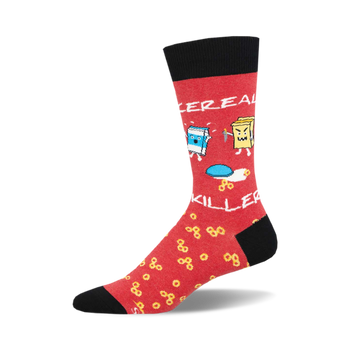 socks that are red with black toes and heels. there is a pattern of yellow cereal rings all over the red part of the sock. there is a bowl of milk on one sock, and a cereal box with a knife in it on the other sock.