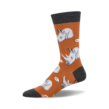 socks that are orange with gray toes, heels, and cuffs. socks with a pattern of cartoonish rhinos wearing party hats and holding a knife and fork. the rhinos are on a white cloud and have speech bubbles that say "no."