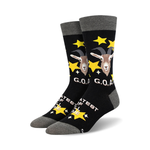 A pair of black crew socks with a goat design, gold stars, and 'G.O.A.T.' text.  The socks have a grey cuff.