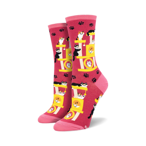 Crew socks in pink featuring a repeating pattern of cats playing on a yellow cat tree. Pink paw prints are scattered across the background.