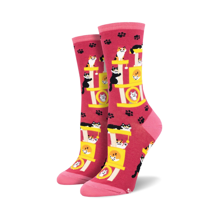 pink crew length socks with a pattern of sleeping black cats on a yellow cat tree with paw prints in the background.   }}