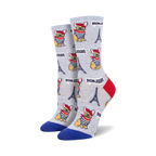 Pair of crew socks with a light grey background featuring illustrations of French bulldogs in sailor shirts, Eiffel Towers, and the word 'Bonjour!'