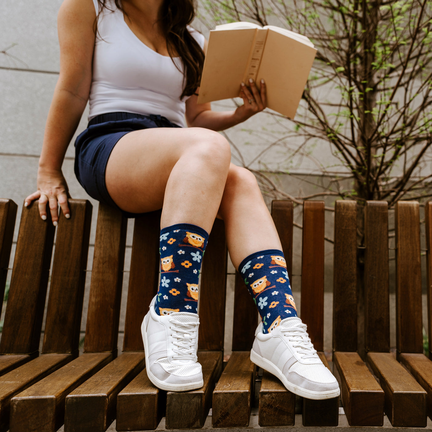 Close-up flatlay showcasing the detail of the owl and flower pattern on the navy blue socks. [lf]