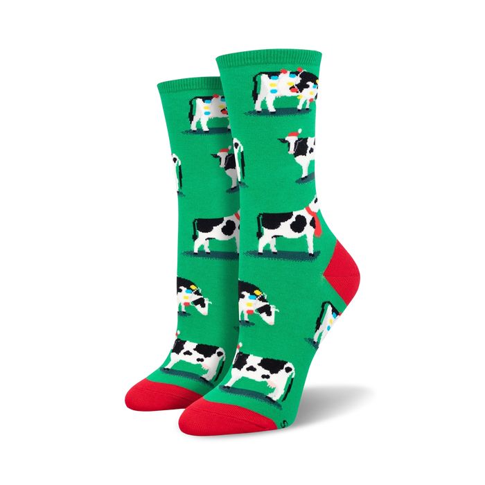 womens crew socks feature christmas themed black and white cows wearing santa hats and scarves surrounded by red and yellow christmas lights.   }}