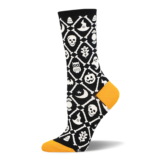 Black crew sock with orange heel and toe. White crossed bones form a lattice filled with skulls, pumpkins, bats, and ghosts.