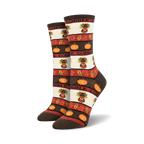 A pair of women's crew socks in brown, orange, and cream. The design includes pilgrim turkeys, pumpkins, and autumn leaves with the word 'Gobble'.