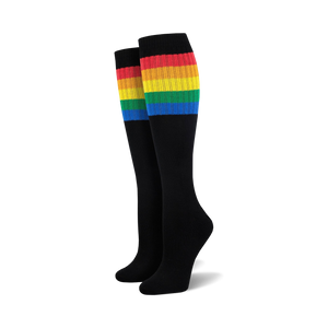 Pair of black knee-high socks with a vibrant rainbow striped cuff against a white background.