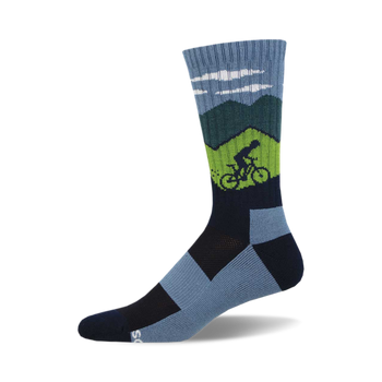 the ride on, ride on, ride on socks are blue with a green and navy blue geometric pattern that resembles mountains. there is a green cyclist on the left sock ascending a mountain. socks with a navy blue toe and heel with a light blue arch support area.