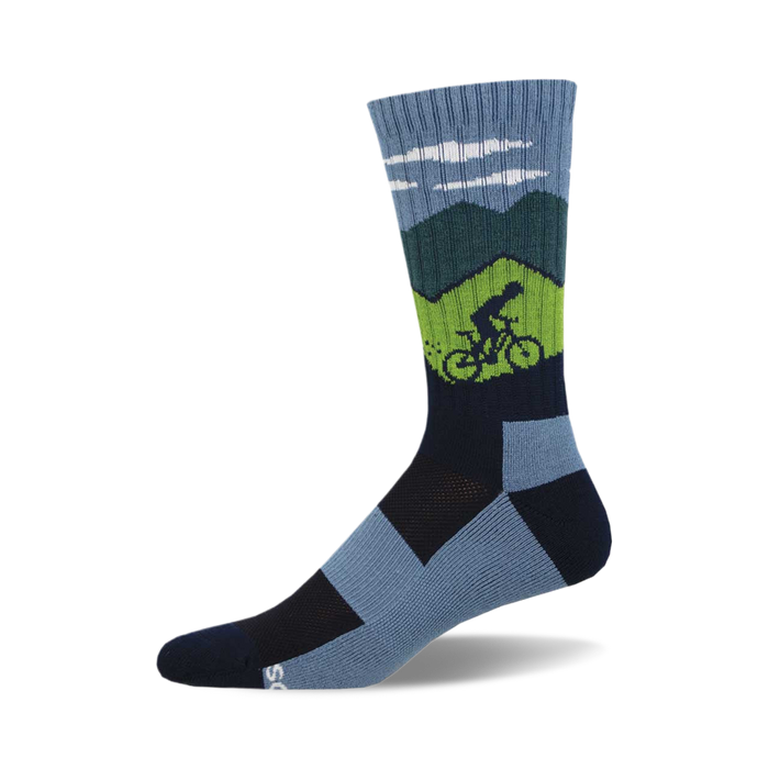 the ride on, ride on, ride on socks are blue with a green and navy blue geometric pattern that resembles mountains. there is a green cyclist on the left sock ascending a mountain. socks with a navy blue toe and heel with a light blue arch support area. }}