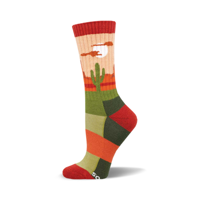 the sock has a pattern of cacti in a desert with mountains in the background. the colors are red, orange, yellow, green, and blue.