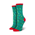 Lifestyle shot of a person wearing red Christmas Lights socks, sitting near a Christmas tree.