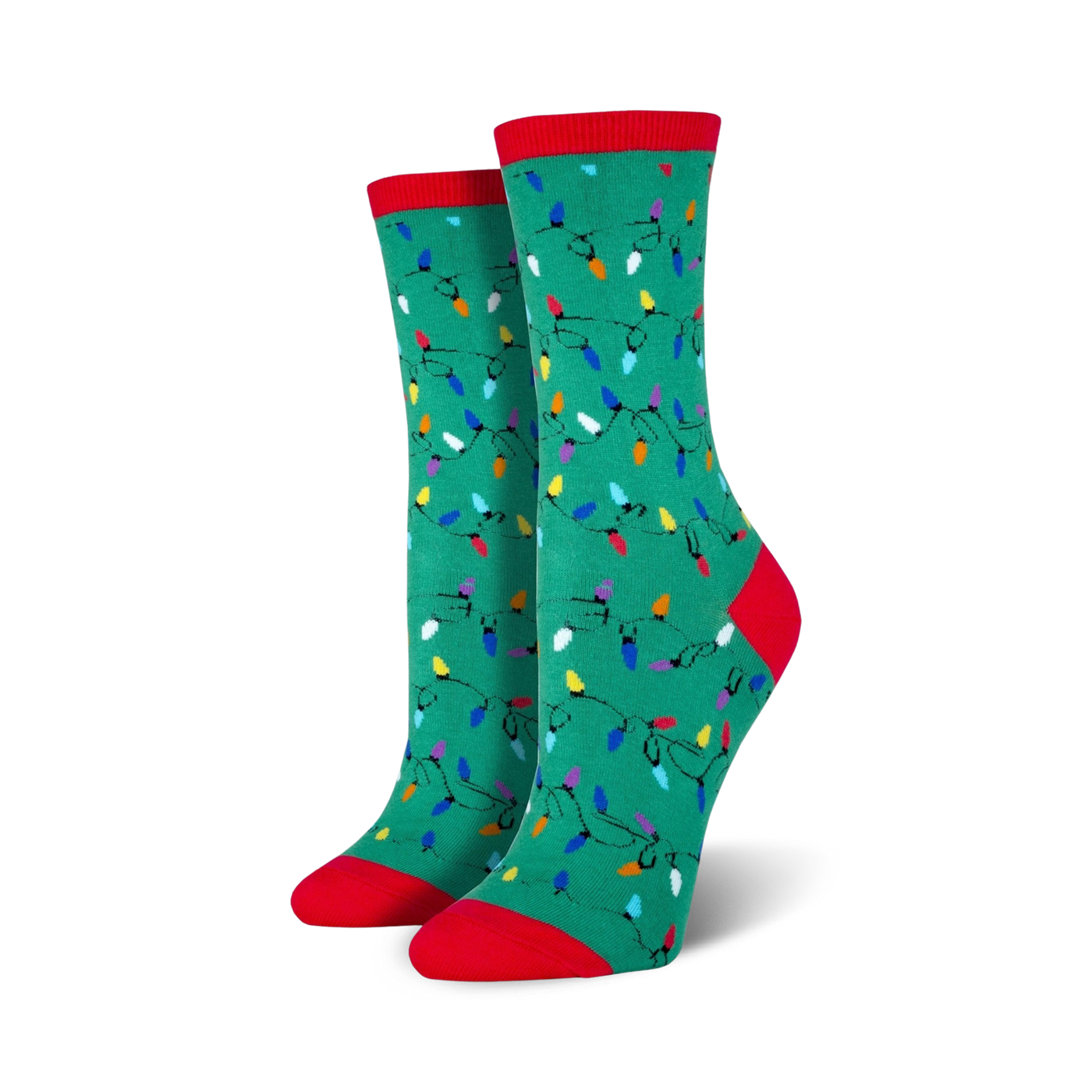 Lifestyle shot of a person wearing red Christmas Lights socks, sitting near a Christmas tree.