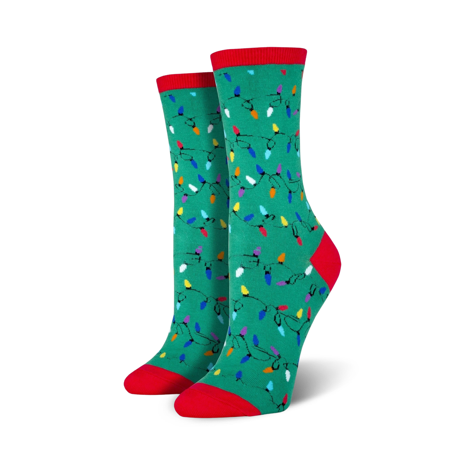 Lifestyle shot of a person wearing red Christmas Lights socks, sitting near a Christmas tree.