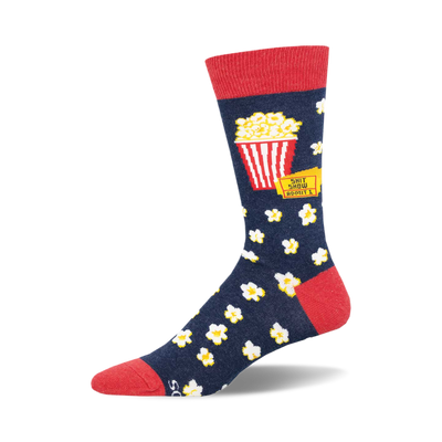 socks that are blue with a red top. there is a picture of a red and white striped popcorn bucket on the socks with the words 'shit show' above it and 'admit 1' below it. there are also white popcorn kernels all over the socks.