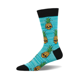 the pineapple people socks are a light blue color with an allover pattern of pixelated skulls wearing pineapple crowns. the skulls are yellow with black details, and the pineapples are green with yellow details.