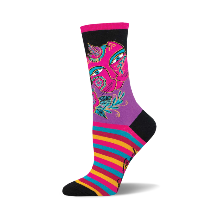 socks that are black, purple, pink, blue, yellow and red. they have a pattern of a cat's face with flowers and birds on it. the cat's face is split in half with one half being a lighter shade of pink than the other half. the eyes are blue and the nose is black. the flowers are pink, yellow, and blue. the leaves are green. the birds are blue and yellow. the socks also have a striped pattern of pink, blue, yellow and red at the end of the sock by the toes. }}